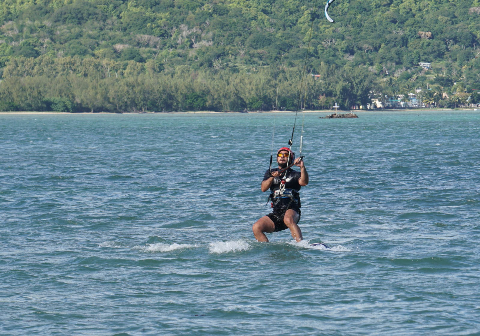 Kitesurfer riding the rolling reef wave at Manawa with Le Morne mountain behind
